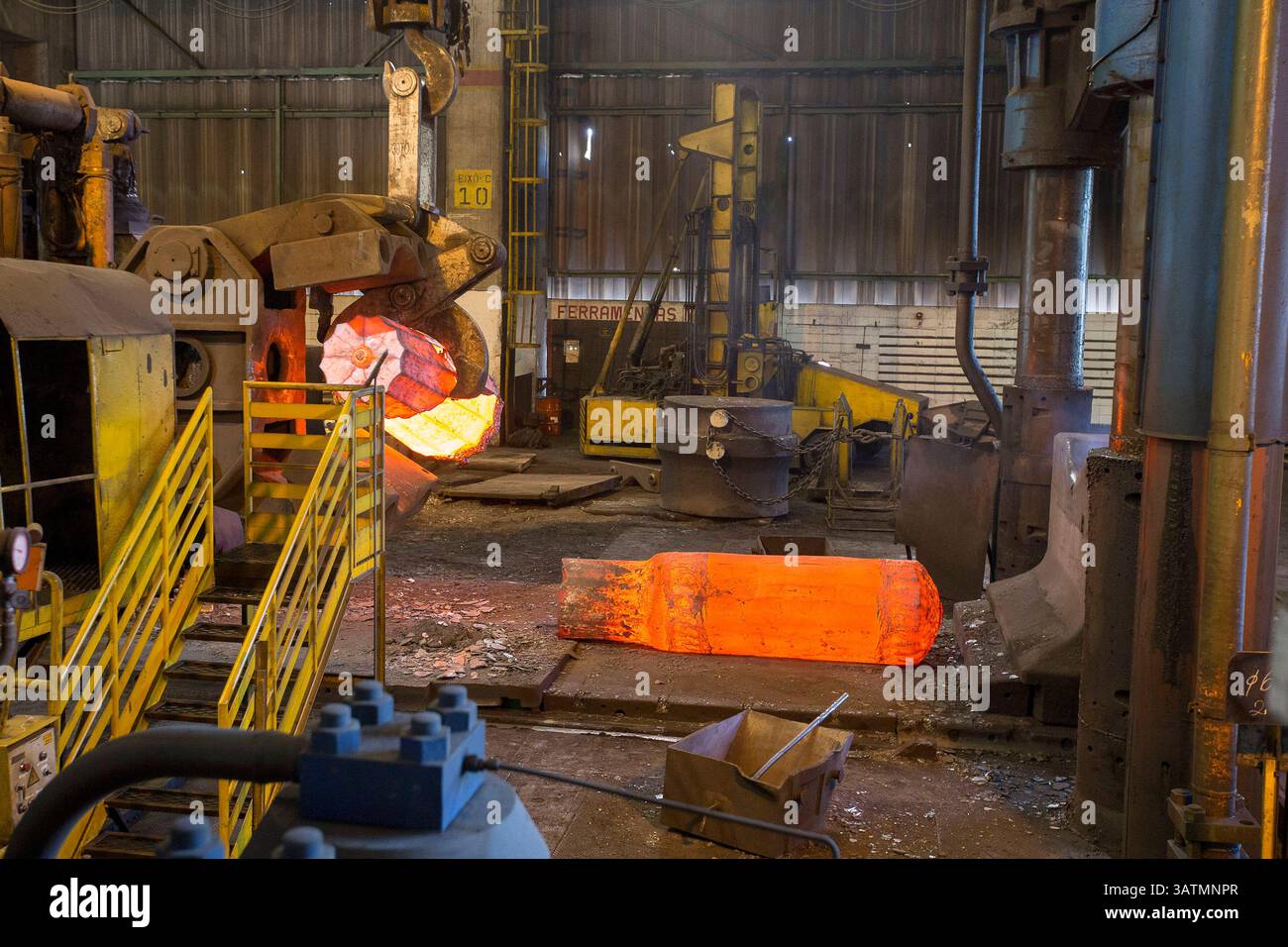 Stato di San Paolo, Brasile - 09 aprile 2018 - fucinatura metallica. il martello idraulico forma la billetta calda rossa. la produzione di componenti ad alta tecnologia. Foto Stock