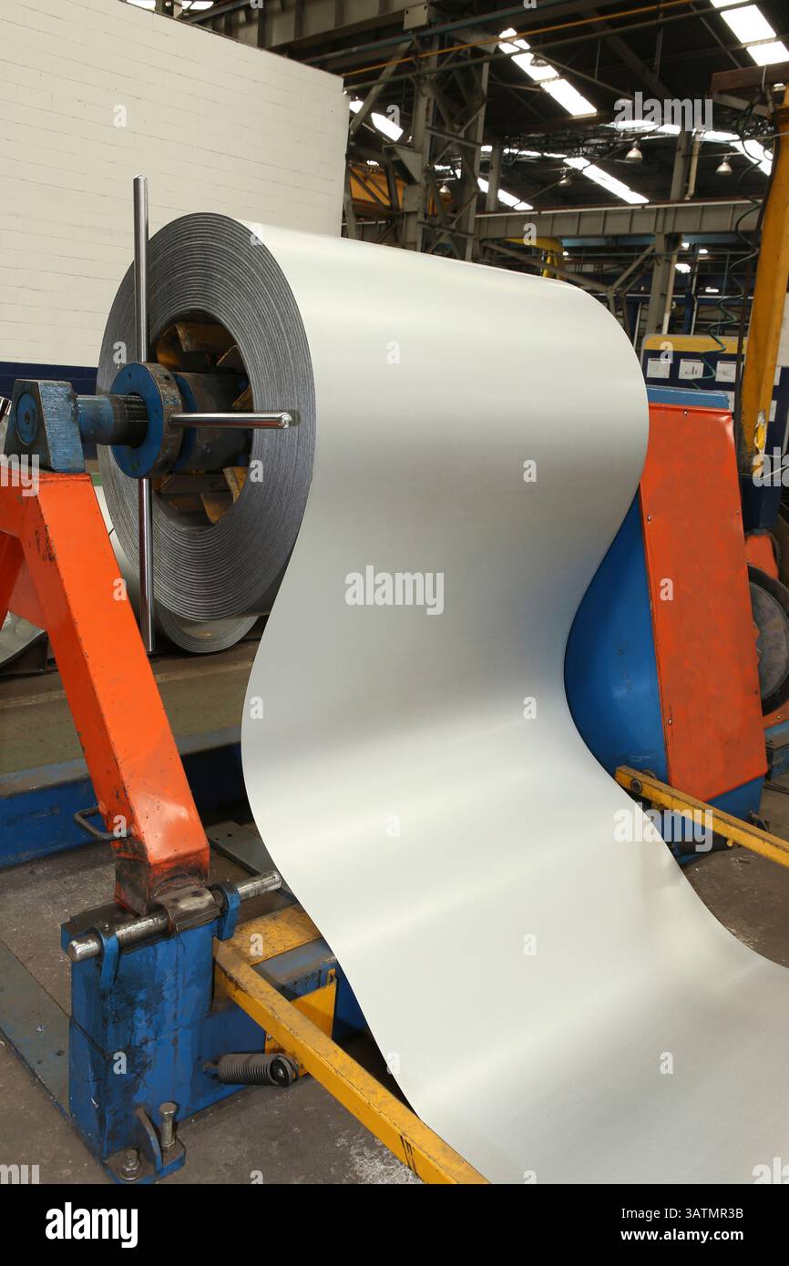 Rotolo di lamiera di acciaio zincato presso la macchina di taglio, la ferramenta e la fabbrica di lavorazione dei metalli per la produzione di tubi e tubi metallici Foto Stock