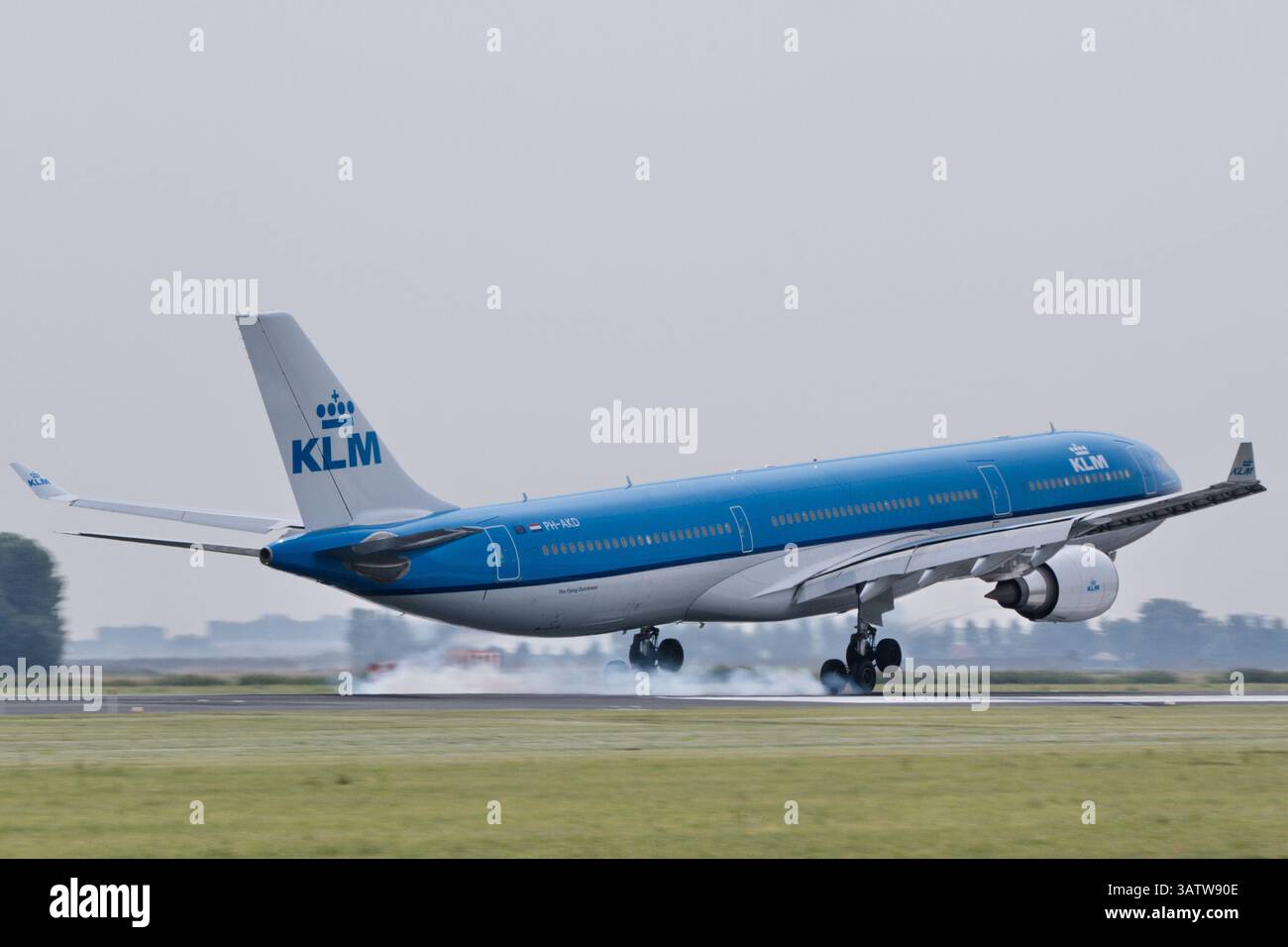 All'aeroporto di Schiphol, nei Paesi Bassi, un Airbus A330-200 (PH-AOD) KLM immacolato atterra perfettamente mentre il fumo degli pneumatici si diffonde attraverso la pista, magia Foto Stock