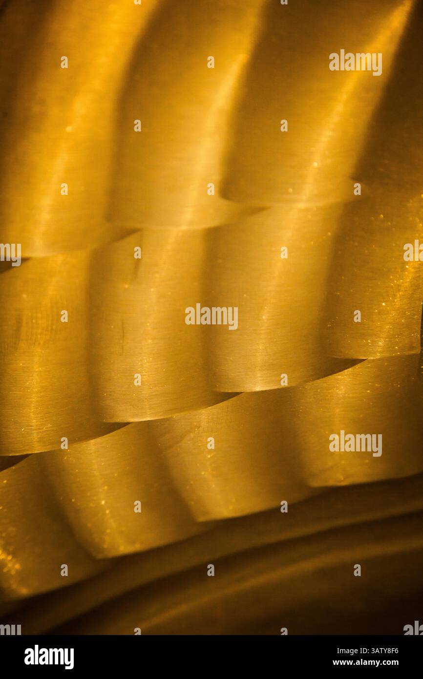 Parte dell'elica di bronzo della nave, primo piano. Nuova texture in bronzo lucido. Superficie non uniforme con trama in bronzo lucido. Foto Stock