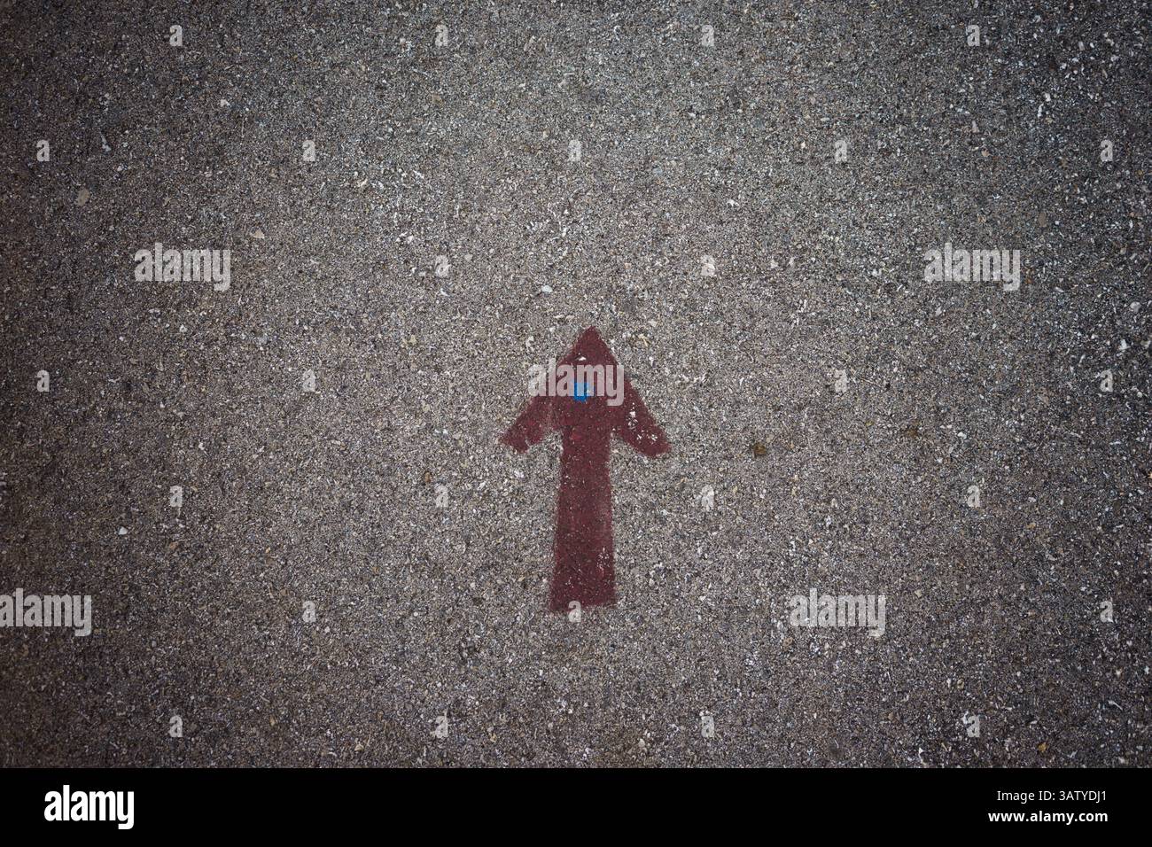 Grafica su asfalto, freccia disegnata in rosso, rivolta verso l'alto. Foto Stock