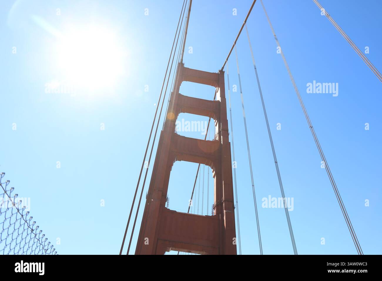 Colonna rossa luminosa del Golden Gate Bridge contro il cielo blu. Foto Stock