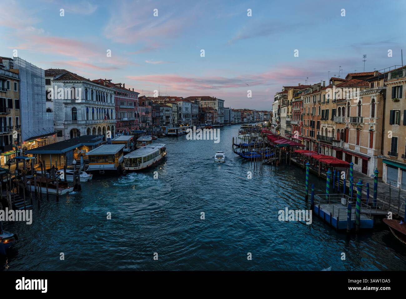 Alba sul Canal grande dal ponte di Rialto con imbarco del traghetto di Rialto e vaporetto, San Marco (a sinistra) e i ristoranti Dorsoduro a destra di Venezia. Foto Stock