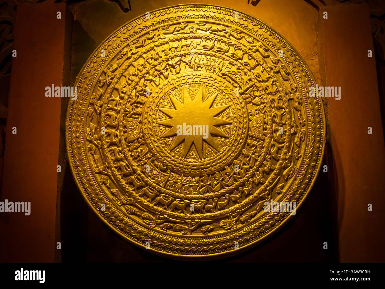 Una rappresentazione di un tamburo di bronzo di Dong Son esposto al Museo ho chi Minh di Hanoi, Vietnam. È caratterizzato da motivi e motivi solari intricati Foto Stock