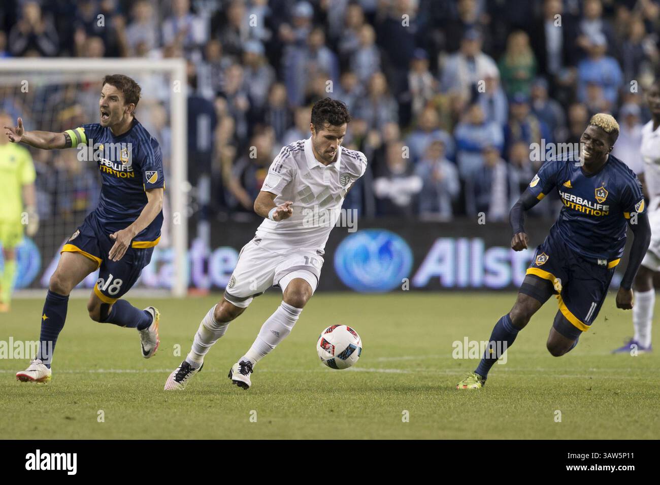 5 marzo 2016 - Kansas City, Kansas, U. S - il centrocampista dello Sporting KC Benny Feilhaber n. 10 (centro) prende il comando dell'attacco. Il centrocampista DELLA Galaxy Mike Magee (a sinistra) #18 segnala il supporto della squadra con l'attaccante DELLA Galaxy Gyasi Zardes #11 (a destra) in posizione. (Immagine di credito: © Serena S.Y.Hsu via ZUMA Wire) Foto Stock