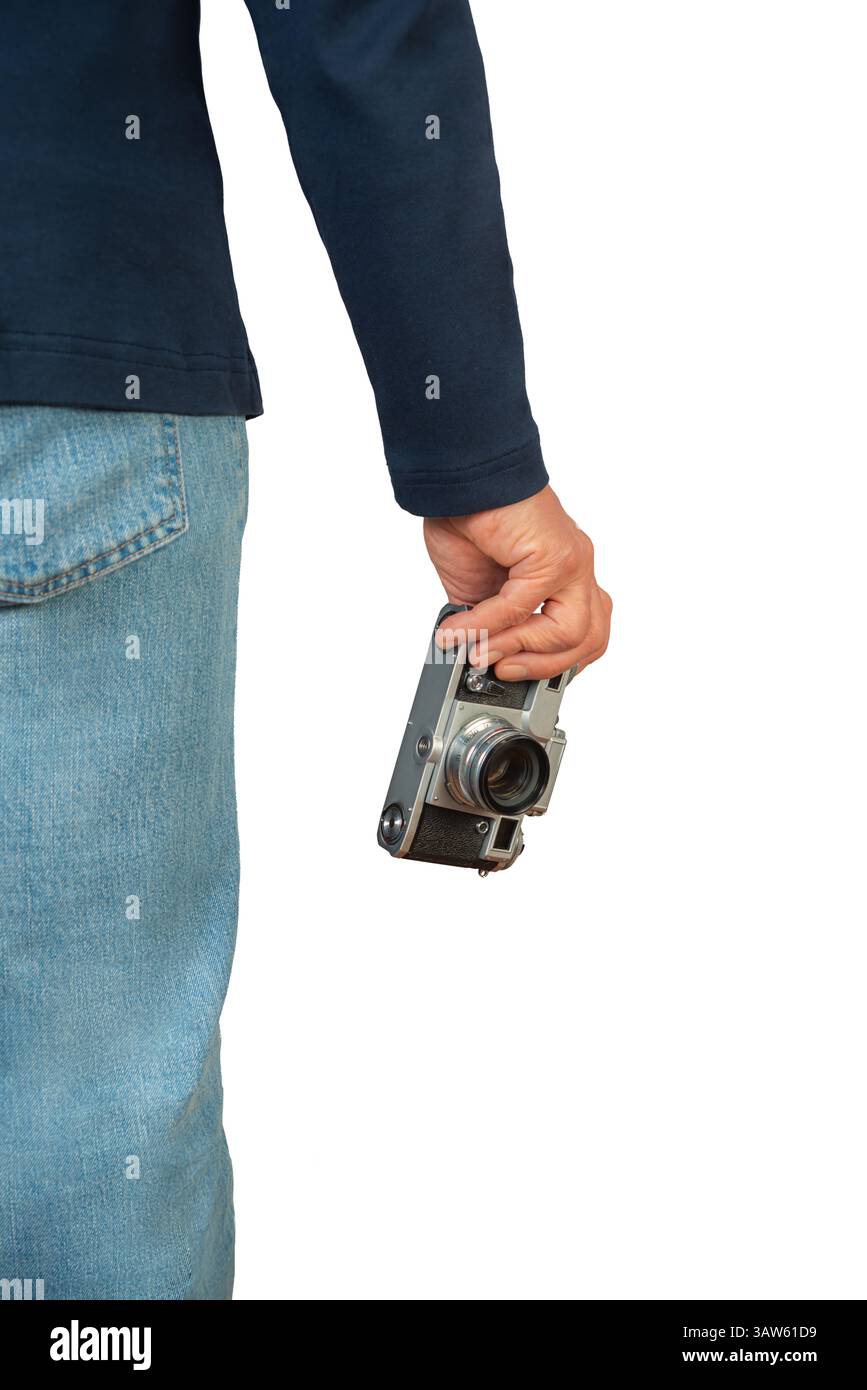 La persona è pronta a documentare le scene con una fotocamera vintage, mostrando la passione per la fotografia in condizioni di luce naturale. Foto Stock