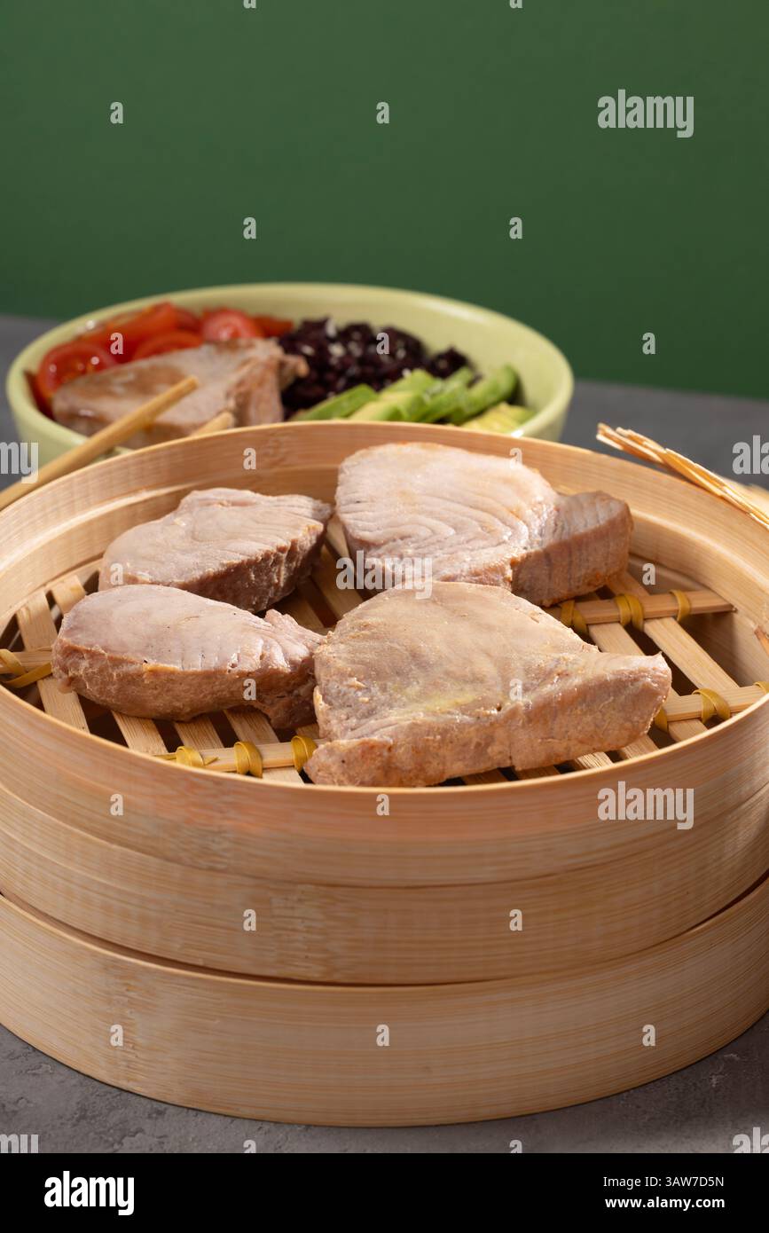 Tonno al vapore in stile tradizionale cinese e giapponese con riso e avocado. Natura morta moderna. Foto di alta qualità Foto Stock
