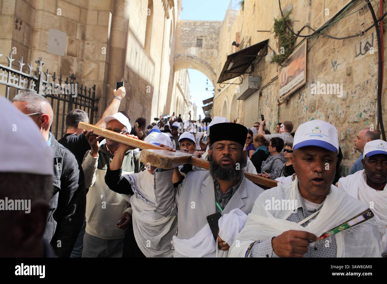 Pellegrini ortodossi etiopi con una croce, passeggia in una processione del venerdì Santo sotto l'Arco Ecce Home sulla via dolorosa nella città vecchia di Gerusalemme. Foto Stock