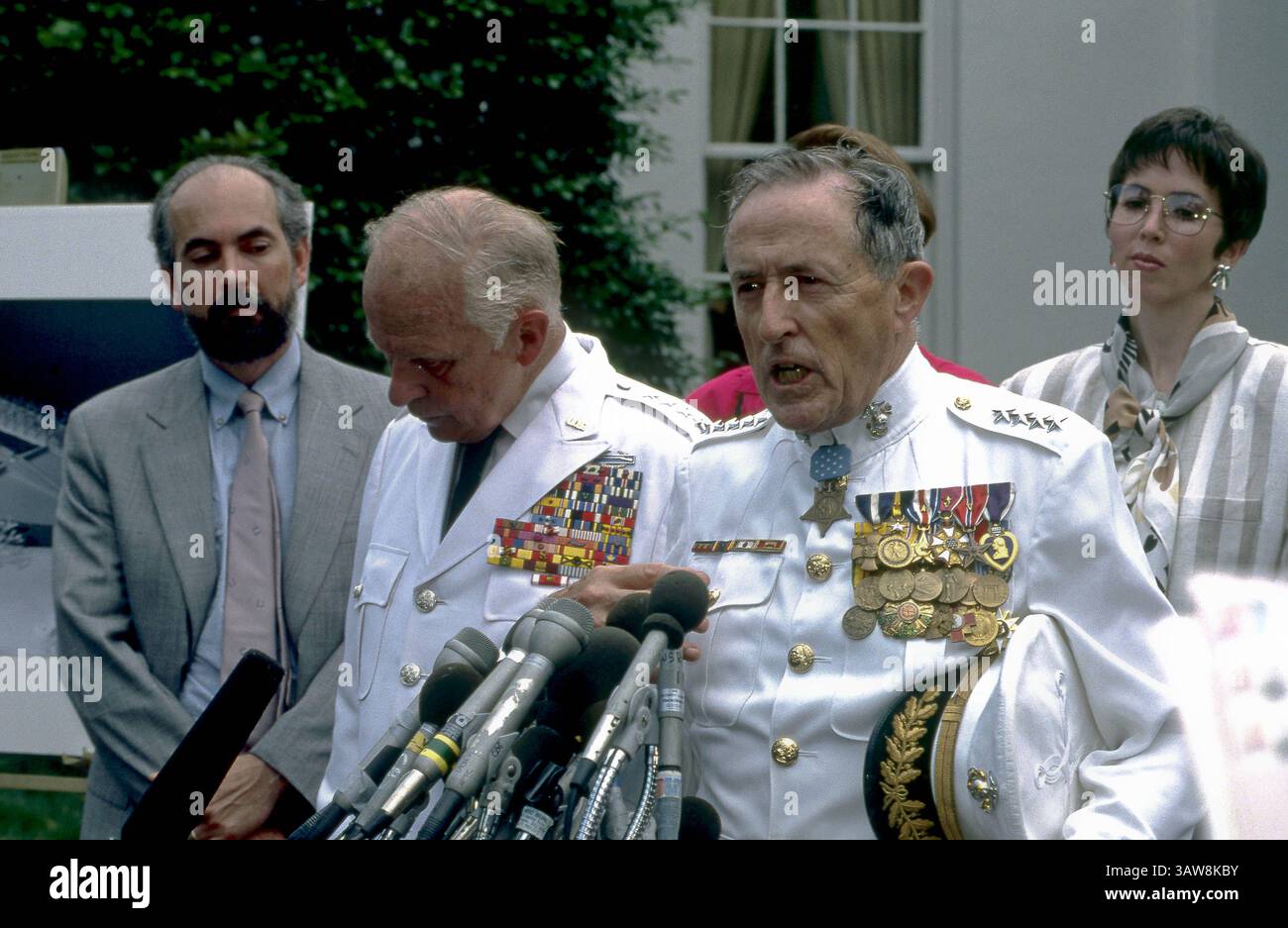 14 giugno 1989 - Washington, Distretto di Columbia, U. S - il generale dei Marines (RET) Ray Davis MOH parla con i giornalisti nel vialetto della Casa Bianca nel West Wing durante la cerimonia per la dedica del Korean War Memorial. Il generale Davis è stato insignito della Medal of Honor per le sue azioni con la First Marine Division nella Battaglia del bacino di Chosin. In piedi con il generale Davis c'è il generale dell'esercito Richard Stilwell che comandò le forze dell'ONU durante la guerra di Corea. (Immagine di credito: © Mark Reinstein via ZUMA Wire) Foto Stock