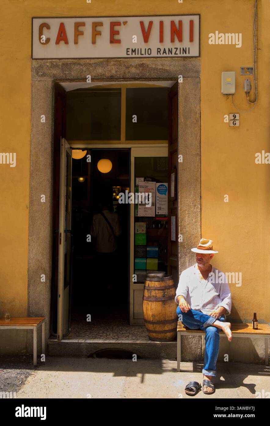 Uomo con un drink che indossa un cappello fuori dal Caffe-vini Emilio Ranzini, Quadrilatero Romano, Torino, Italia. Foto Stock