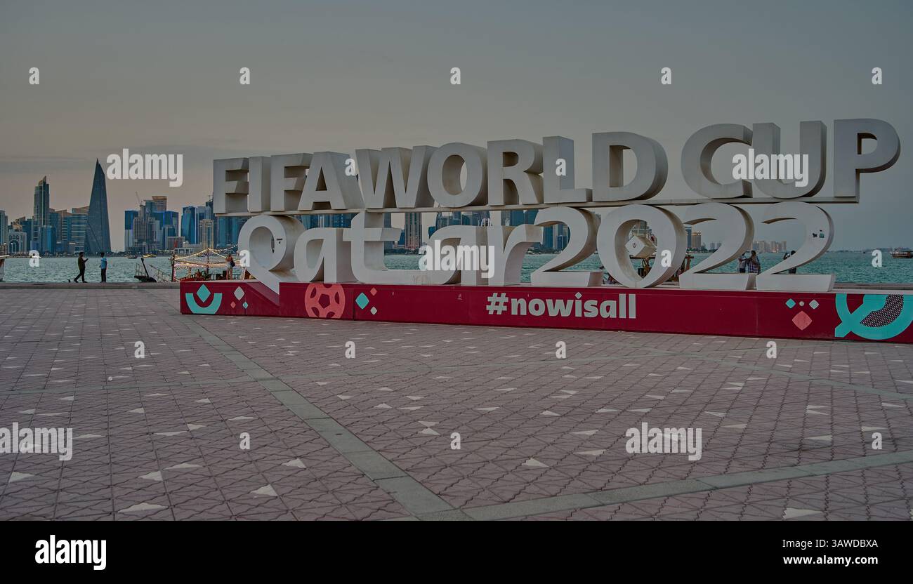 Doha Corniche , Qatar che mostra il segno della Coppa del mondo FIFA Qatar 2022 con persone che camminano e lo skyline di Doha sullo sfondo Foto Stock