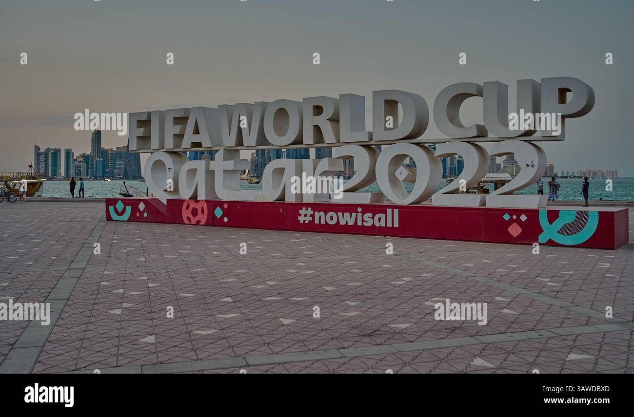 Doha Corniche , Qatar che mostra il segno della Coppa del mondo FIFA Qatar 2022 con persone che camminano e lo skyline di Doha sullo sfondo Foto Stock