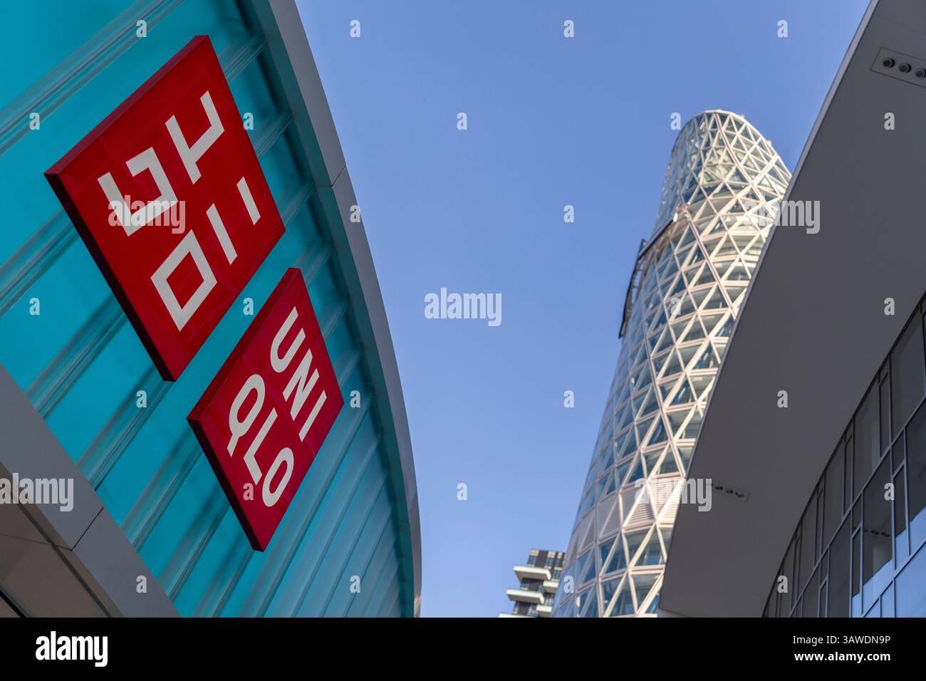 Como, Italia - 4 aprile 2025: Negozio Uniqlo a Milano con la Torre Unipol sullo sfondo Foto Stock