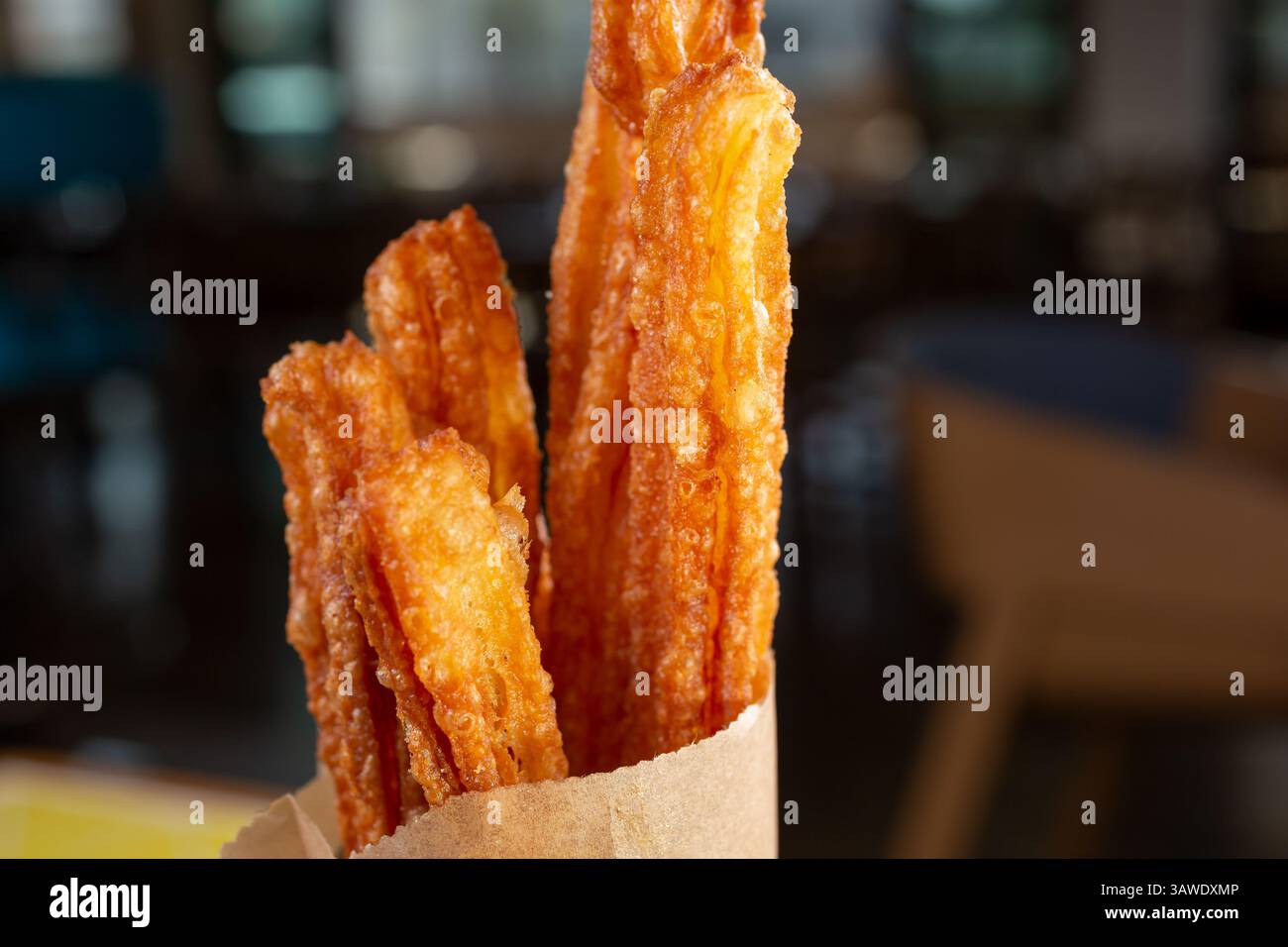 Vista ravvicinata di una borsa di churros messicani appena fatti, in un ristorante o in cucina. Foto Stock