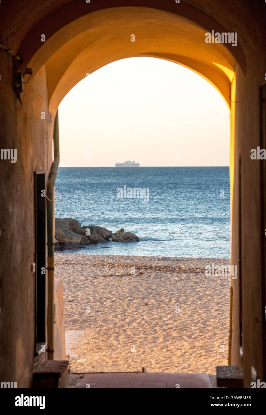 Spiaggia di Varigotti. Spiaggia di Varigotti. Un arco che porta alla spiaggia e al mare della Liguria. Spiaggia sabbiosa, rocce e navi all'orizzonte. Varigotti è una frazione del comune di finale Ligure, in Liguria. Foto Stock