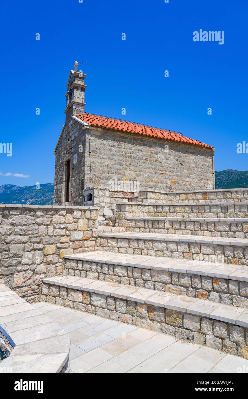 Chiesa di Santa Sava, un luogo di culto serbo ortodosso che si affaccia su Sveti Stefan lungo la costa del Mar Adriatico in Montenegro Foto Stock