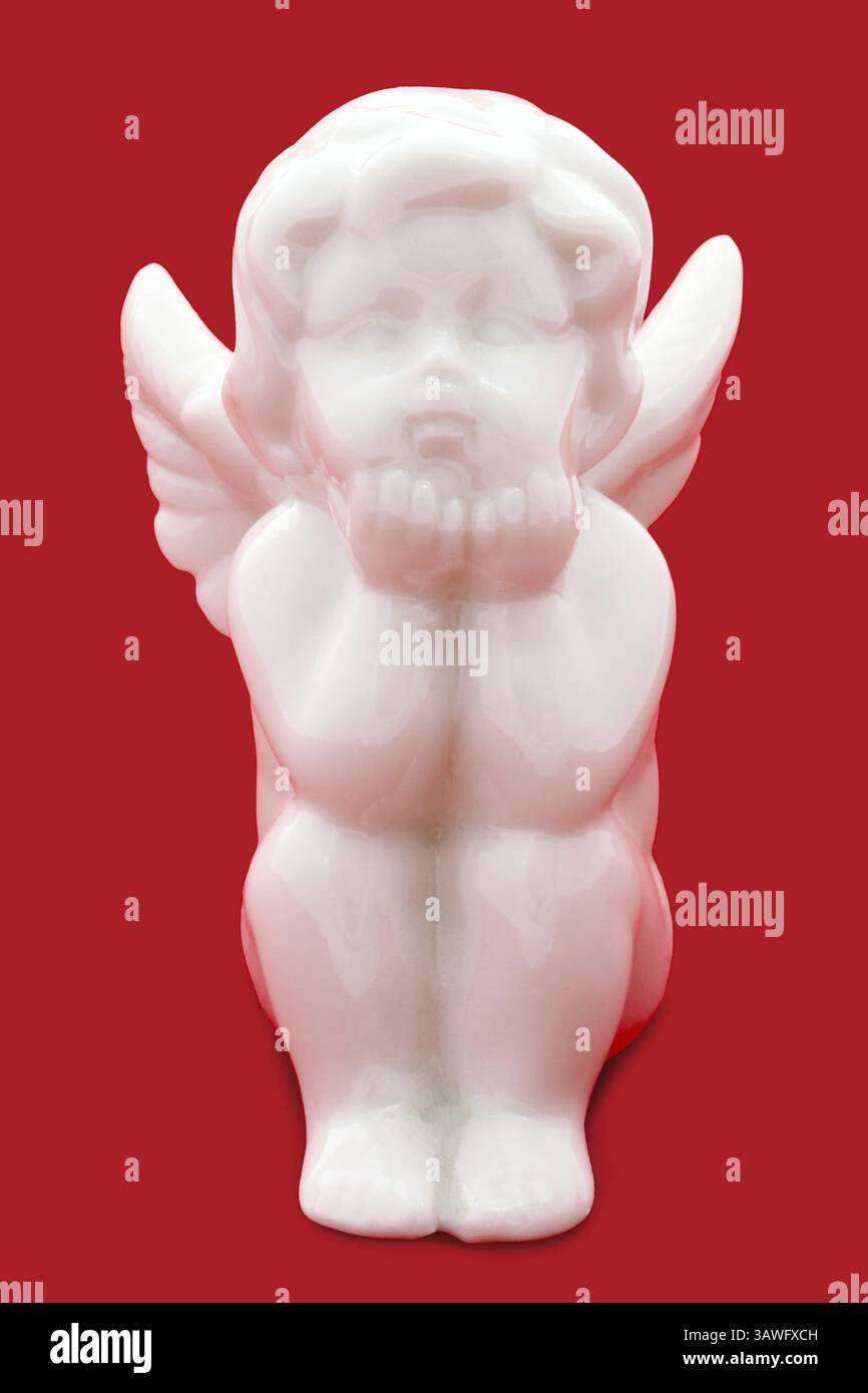 Angelo in porcellana bianco davanti a sfondo rosso angelo cinese bianco su sfondo rosso Foto Stock
