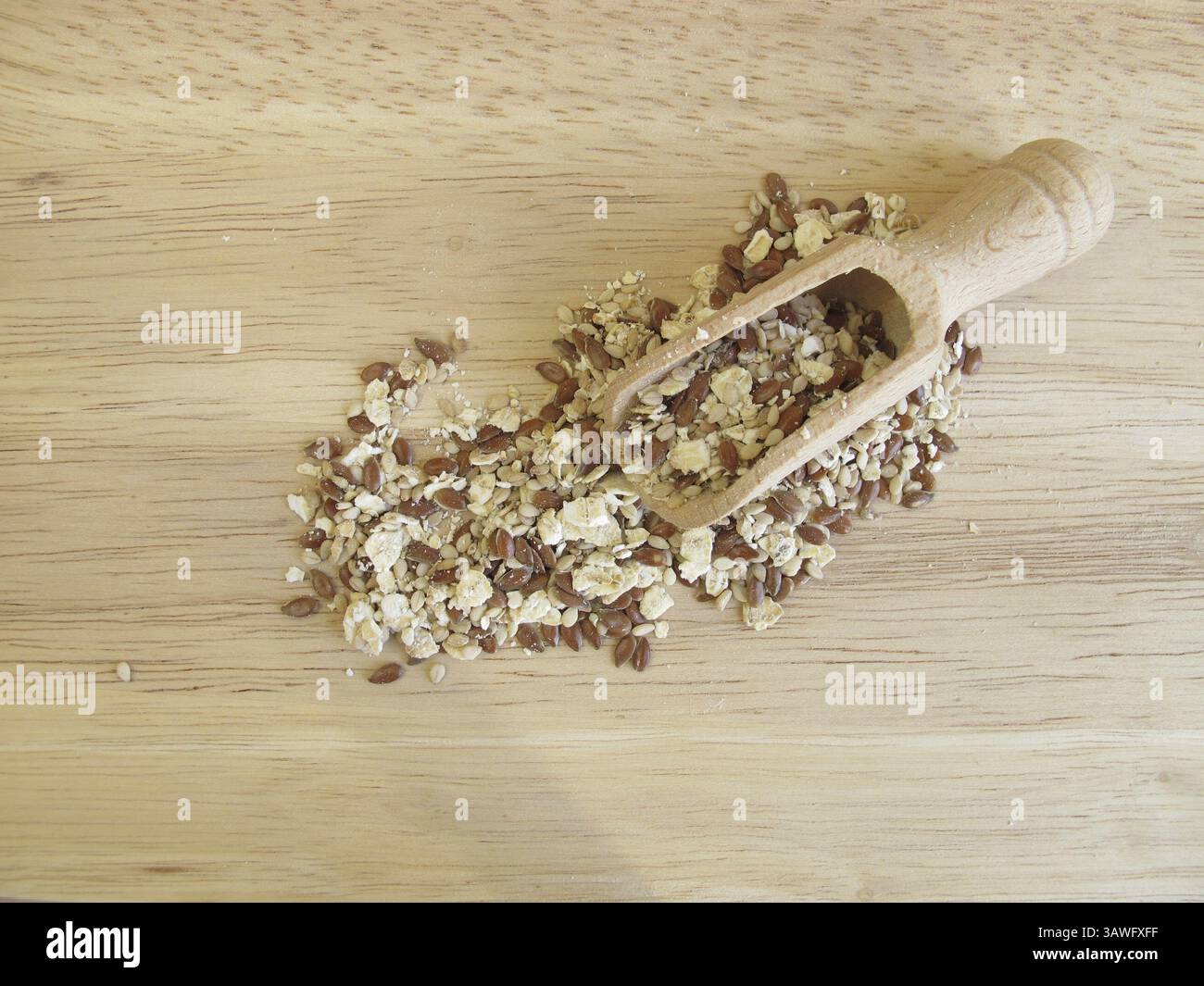 Miscela di semi con fiocchi d'avena, semi di lino e semi di sesamo su un asse di legno Foto Stock