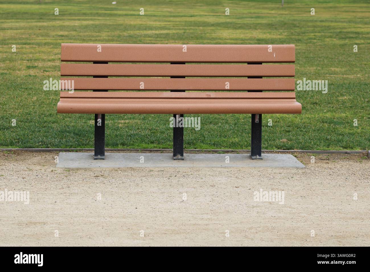 panchina di brown park vicino all'erba Foto Stock