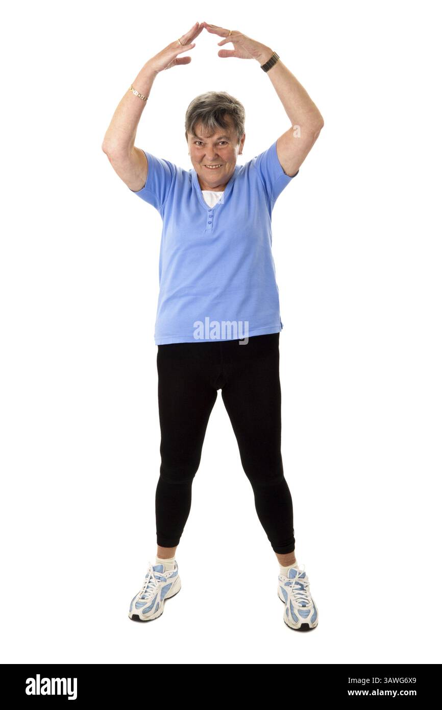Donna anziana che fa esercizi di stretching - donna anziana isolata che fa esercizi di stretching - isolata Foto Stock