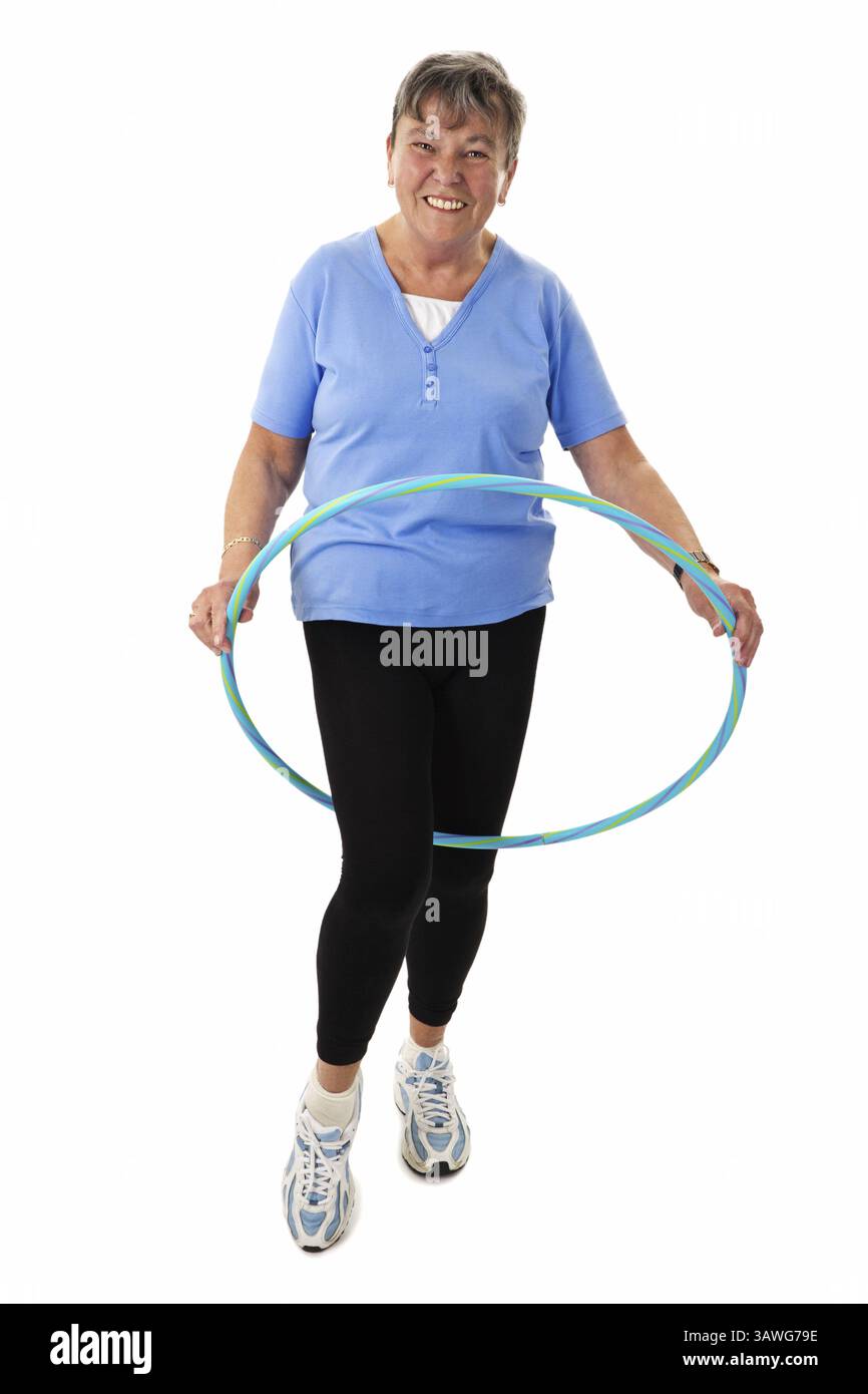 Donna anziana che fa esercizio con hula-hoop - donna anziana isolata che fa esercizio con hula-hoop - isolata Foto Stock