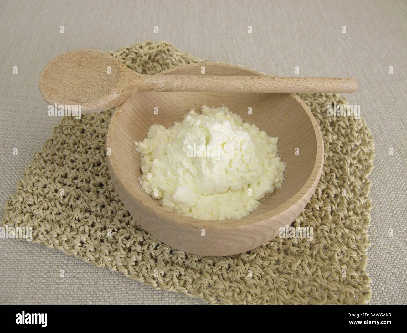 Latte in polvere in un piccolo recipiente di legno Foto Stock