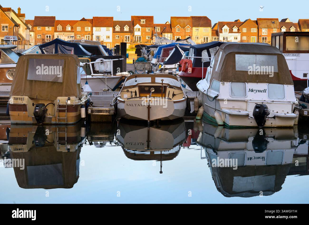 Barche ormeggiate a Abingdon Marina all'alba. Abingdon-on-Thames sostiene di essere la città più antica d'Inghilterra. E il fiume Tamigi scorre attraverso il suo cuore. Qui vedremo il suo esclusivo porticciolo sul fiume, pieno di barche da diporto e illuminato da una luminosa alba primaverile. Foto Stock