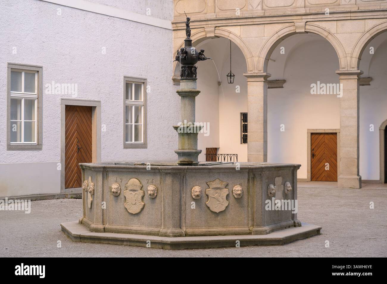 L'elegante cortile del Landhaus di Linz, Austria, presenta una fontana splendidamente realizzata circondata da splendidi elementi architettonici. La tranquillità Foto Stock