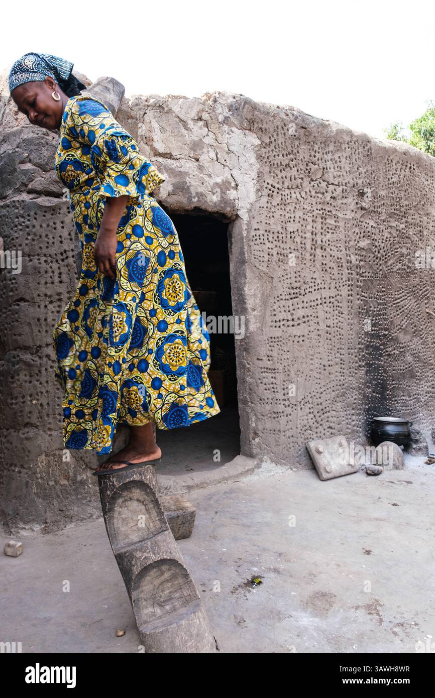 Sonyo, Ghana. Donna che scende dalla scalinata scolpita dal suo tetto. Foto Stock