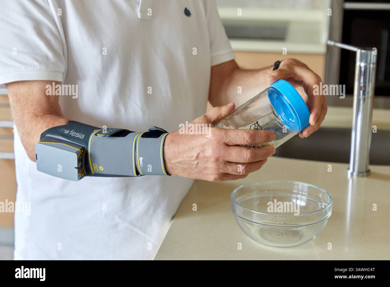 Dispositivo di riabilitazione basato sulla stimolazione elettrica funzionale (FES) che genera flessione ed estensione del polso e delle dita nelle persone con lo spirito Foto Stock