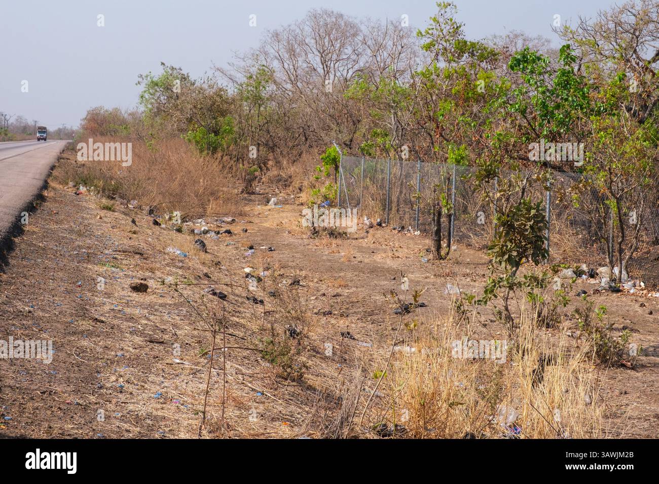 Ghana, la lettiera di plastica scartata copre il terreno lungo le autostrade nazionali. Foto Stock