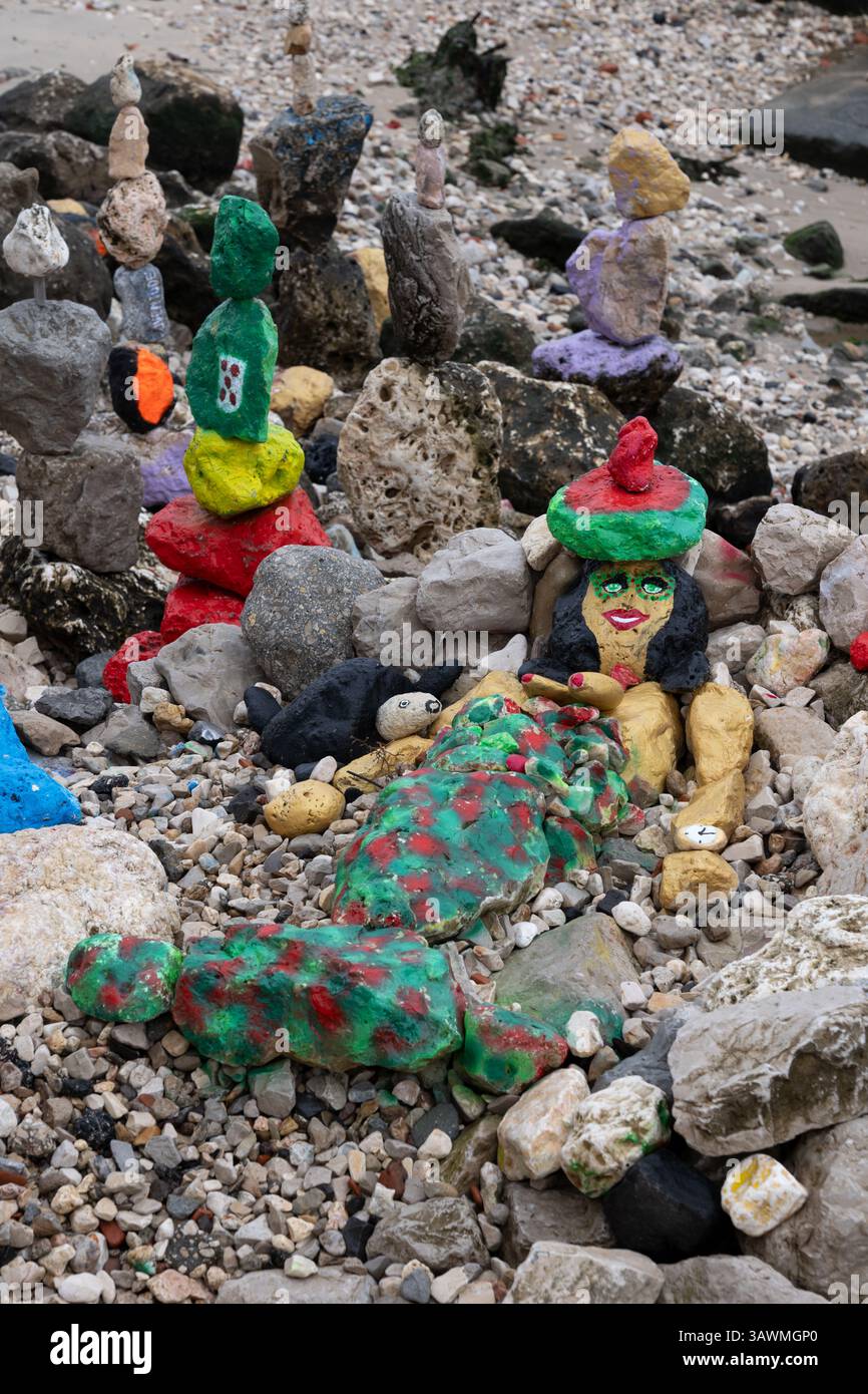 Sculture in pietre dipinte, arte semplice sulla spiaggia di ciottoli sulla riva dell'estuario del fiume Tago a Lisbona, Portogallo. Foto Stock