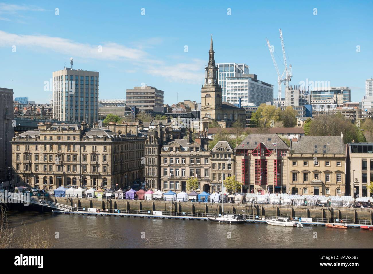 Bancarelle del mercato domenicale sul lungofiume con paesaggio urbano alle spalle, Newcastle upon Tyne, Inghilterra, Regno Unito Foto Stock