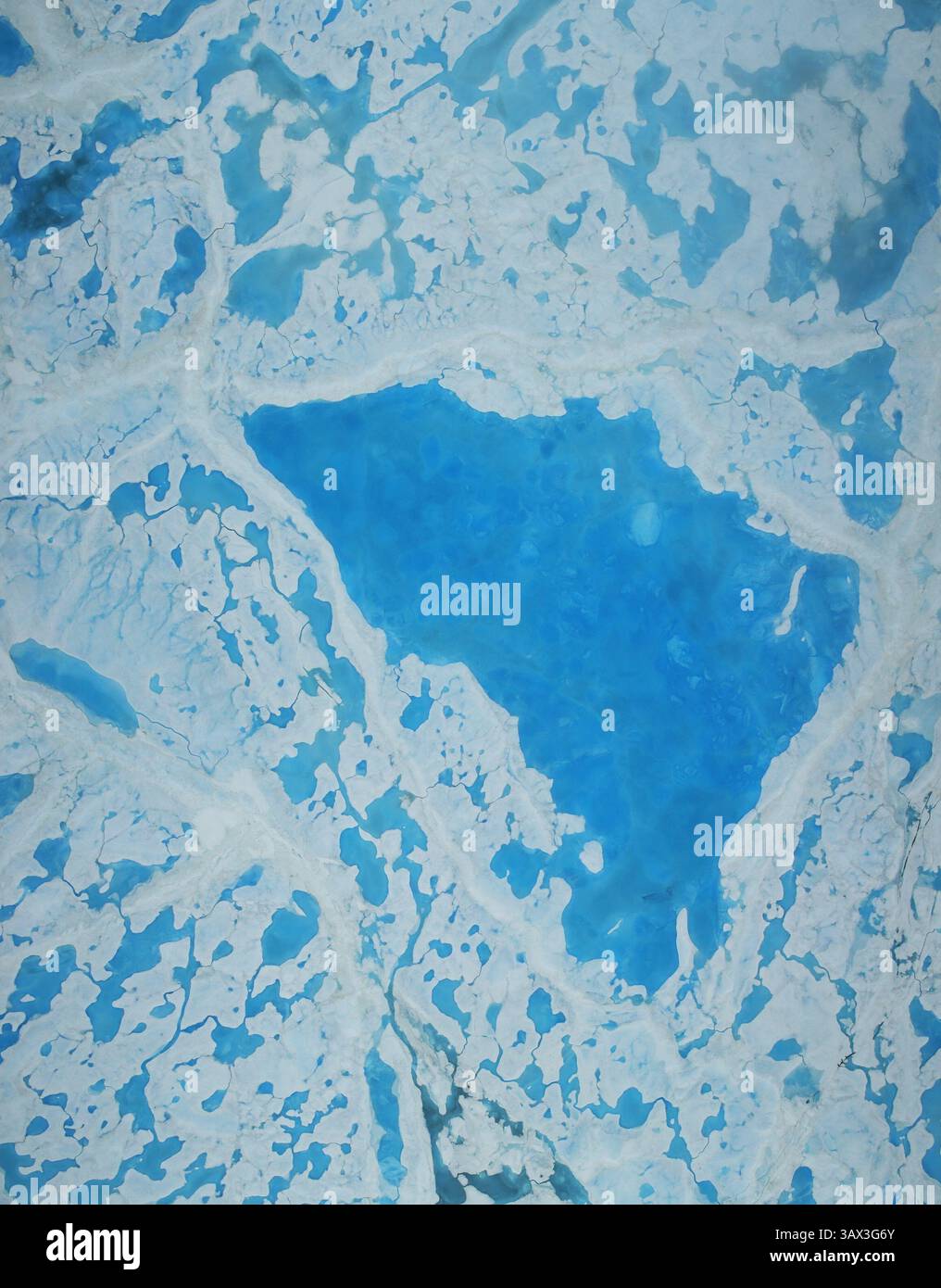 19 luglio 2016 - Oceano Artico - il ghiaccio marino che attraversa l'Oceano Artico si sta restringendo fino a livelli inferiori alla media quest'estate. L'operazione IceBridge della NASA, una ricognizione aerea del ghiaccio polare, ha appena completato i suoi primi voli studiando le piscine acquamarine di acqua sciolta sulla superficie ghiacciata che potrebbe accelerare il ritiro complessivo del ghiaccio marino. Questa grande piscina di acqua sciolta sul ghiaccio marino è stata vista da un volo dell'operazione IceBridge sul Mare di Beaufort il 14 luglio 2016. Durante questa campagna estiva, IceBridge mapperà l'estensione, la frequenza e la profondità degli stagni di fusione come questi per aiutare gli scienziati a prevedere l'ic del mare artico Foto Stock