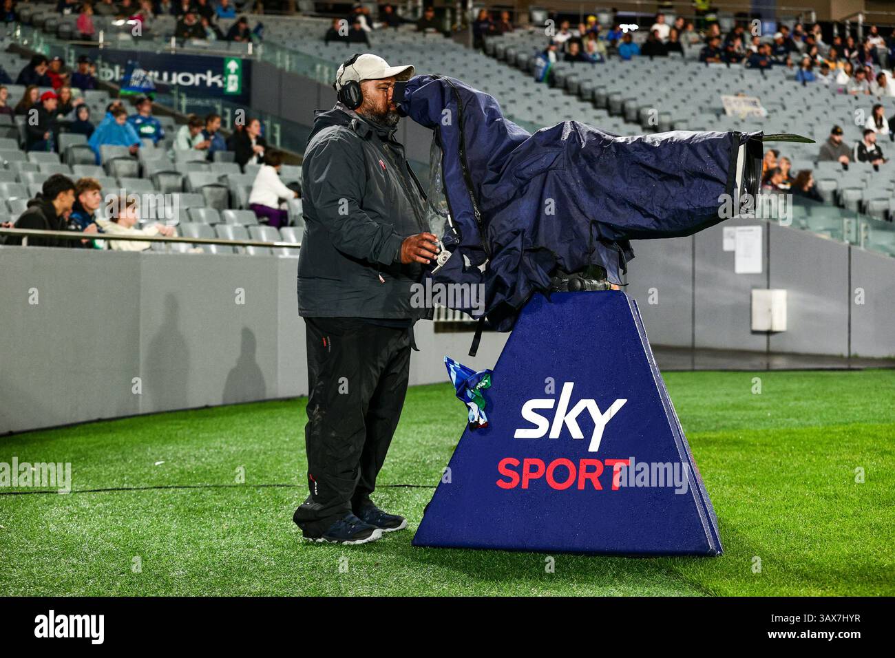 Un operatore Sky Sport camera cattura l'azione sportiva allo stadio durante un evento serale. Foto Stock