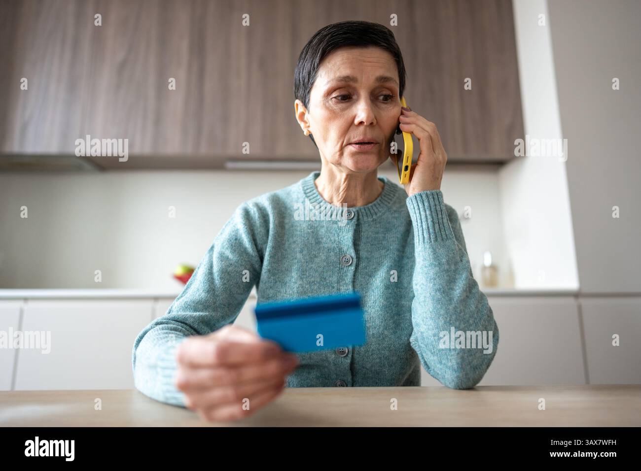 Donna nervosa che trasferisce denaro a truffatori frode telefonica inganno furto d'identità crimine finanziario Foto Stock