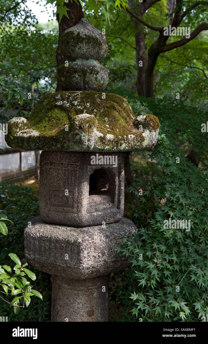 Una lanterna in pietra in stile Kasuga ricoperta di muschio (ishidoro) sorge tra il verde del giardino Oikeniwa presso il Palazzo Imperiale Gosho a Kyoto, in Giappone. Foto Stock