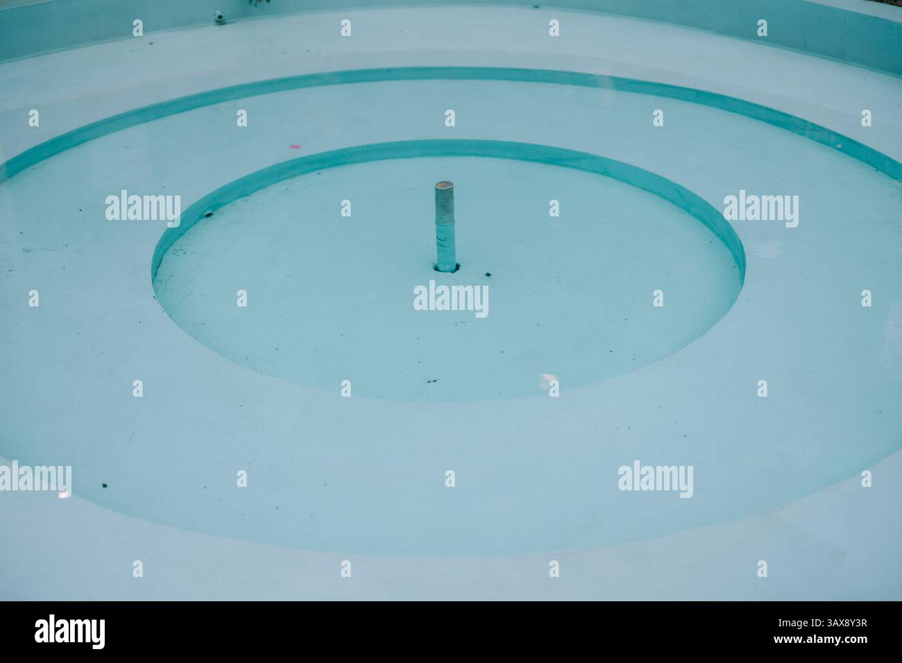 Vista minimalista di una fontana secca con struttura circolare, design pulito e moderno. Foto Stock