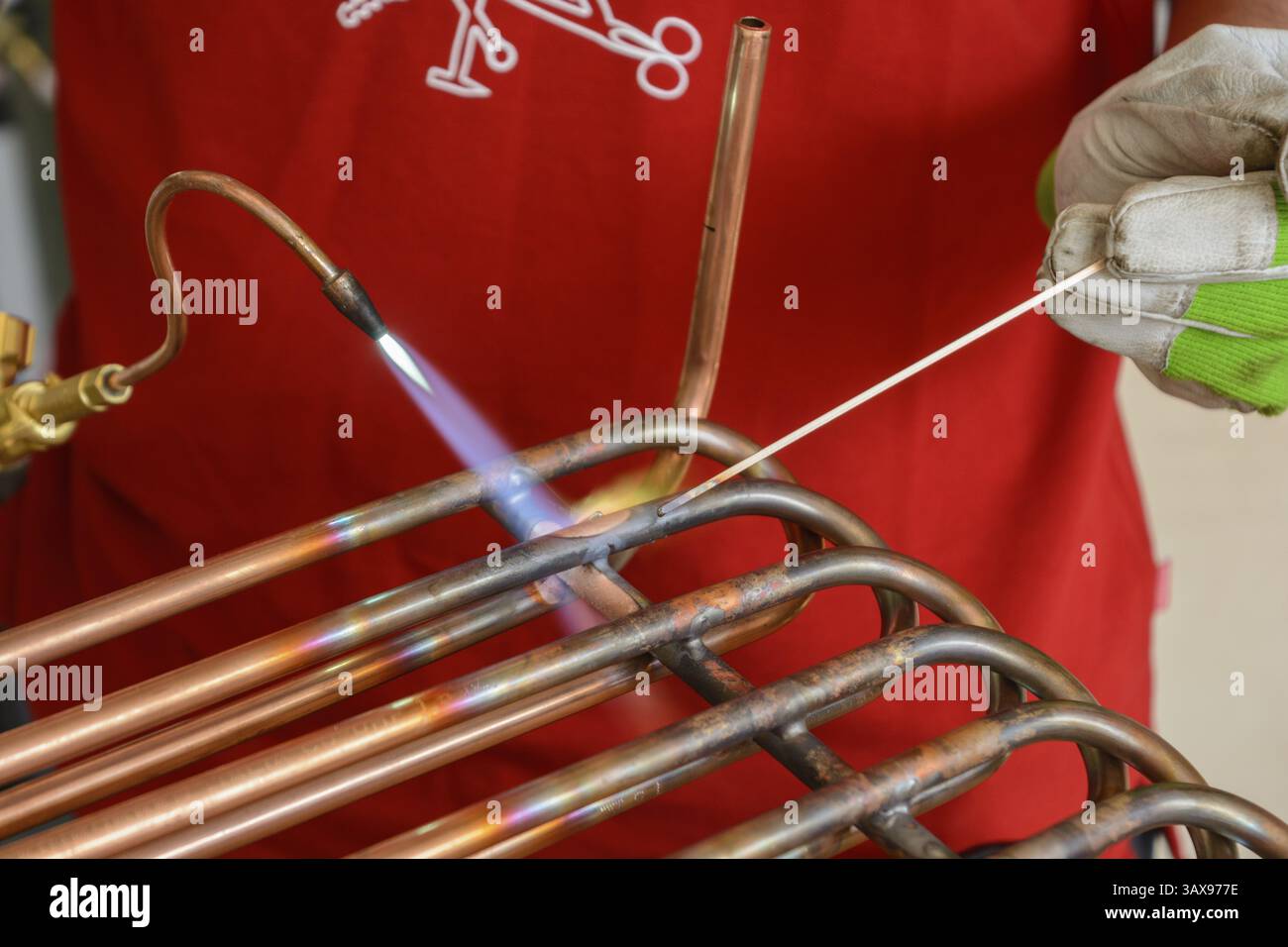 Lavoratore qualificato lavora tubi in rame - brasatura ravvicinata Foto Stock