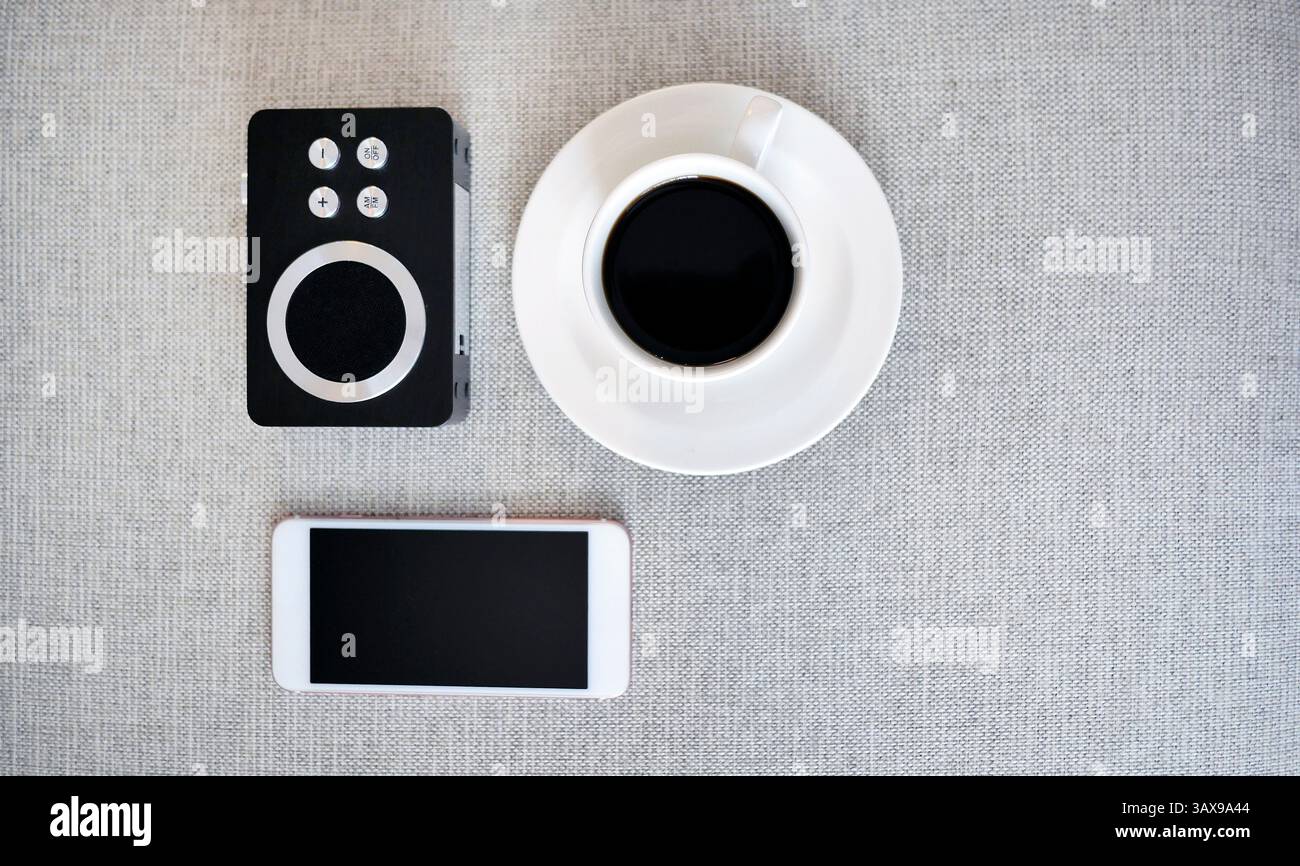 Mockup smartphone dall'alto, una tazza di caffè nero e ricevitore radio analogico, NOMADE digitale, postazione di lavoro libera o concetto di shopping online, retro sty Foto Stock