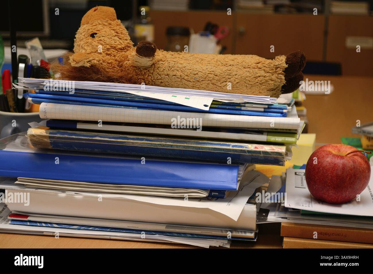 I documenti si accumulano sulla postazione di lavoro dell'ufficio Foto Stock