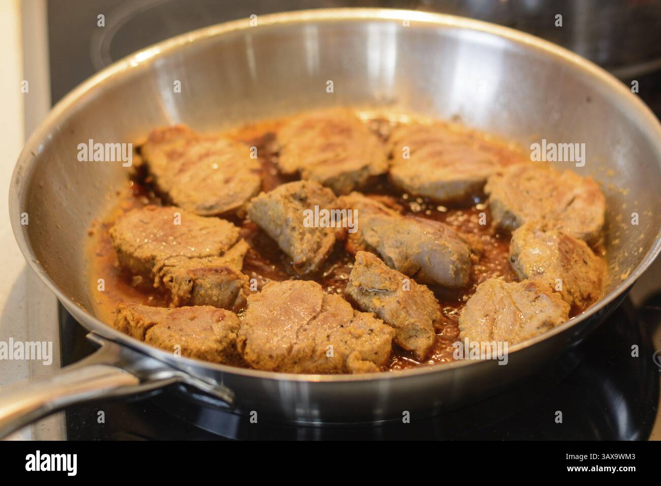 Deliziosi medaglioni di maiale vengono saltati in una padella con una buona salsa Foto Stock