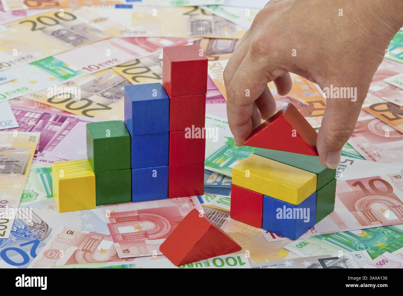 Grafico a barre e casa in blocchi da costruzione su banconote in euro Foto Stock