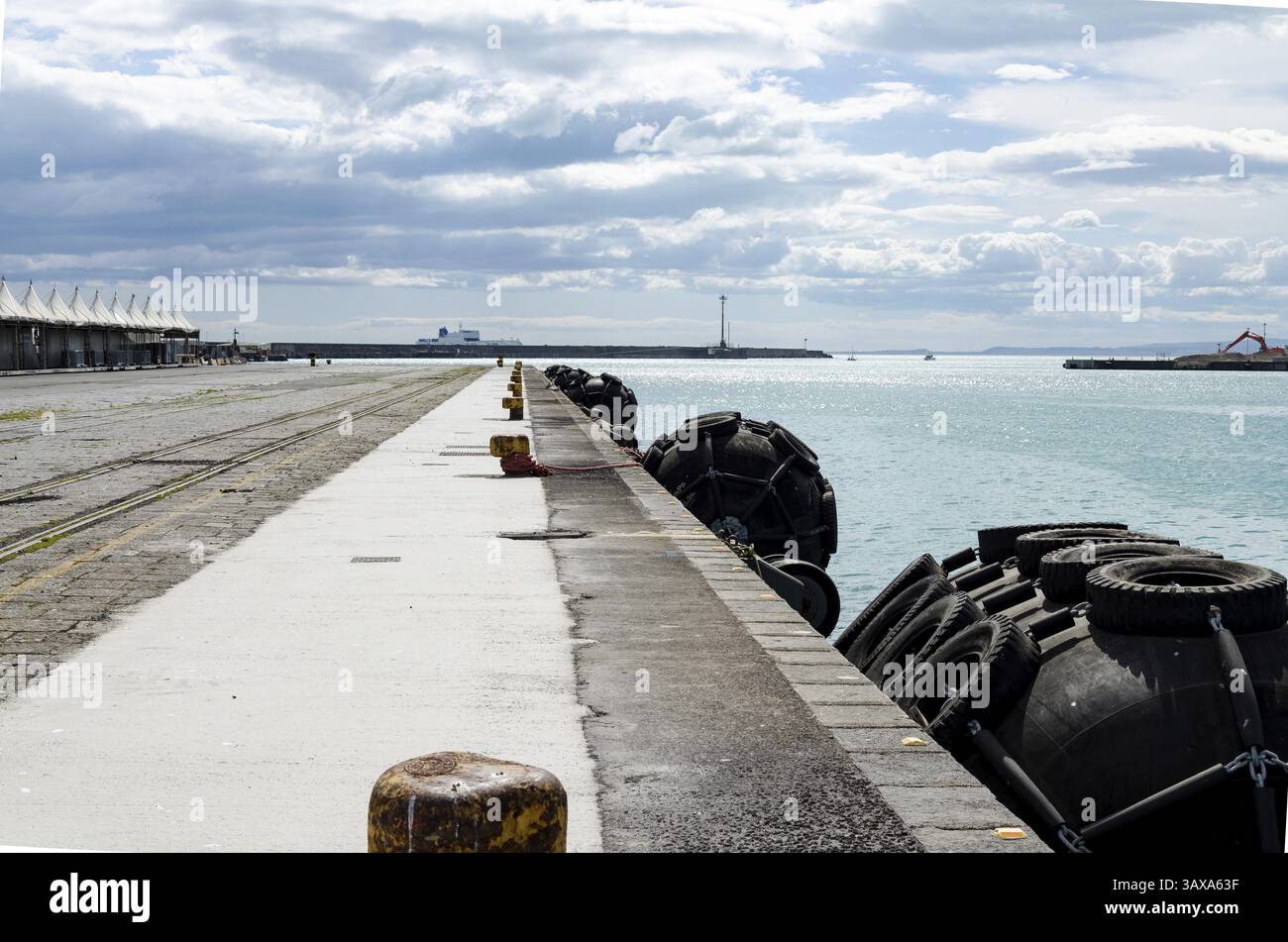 Parafanghi neri sedi sferiche sul bordo di una banchina per le barche di protezione Foto Stock