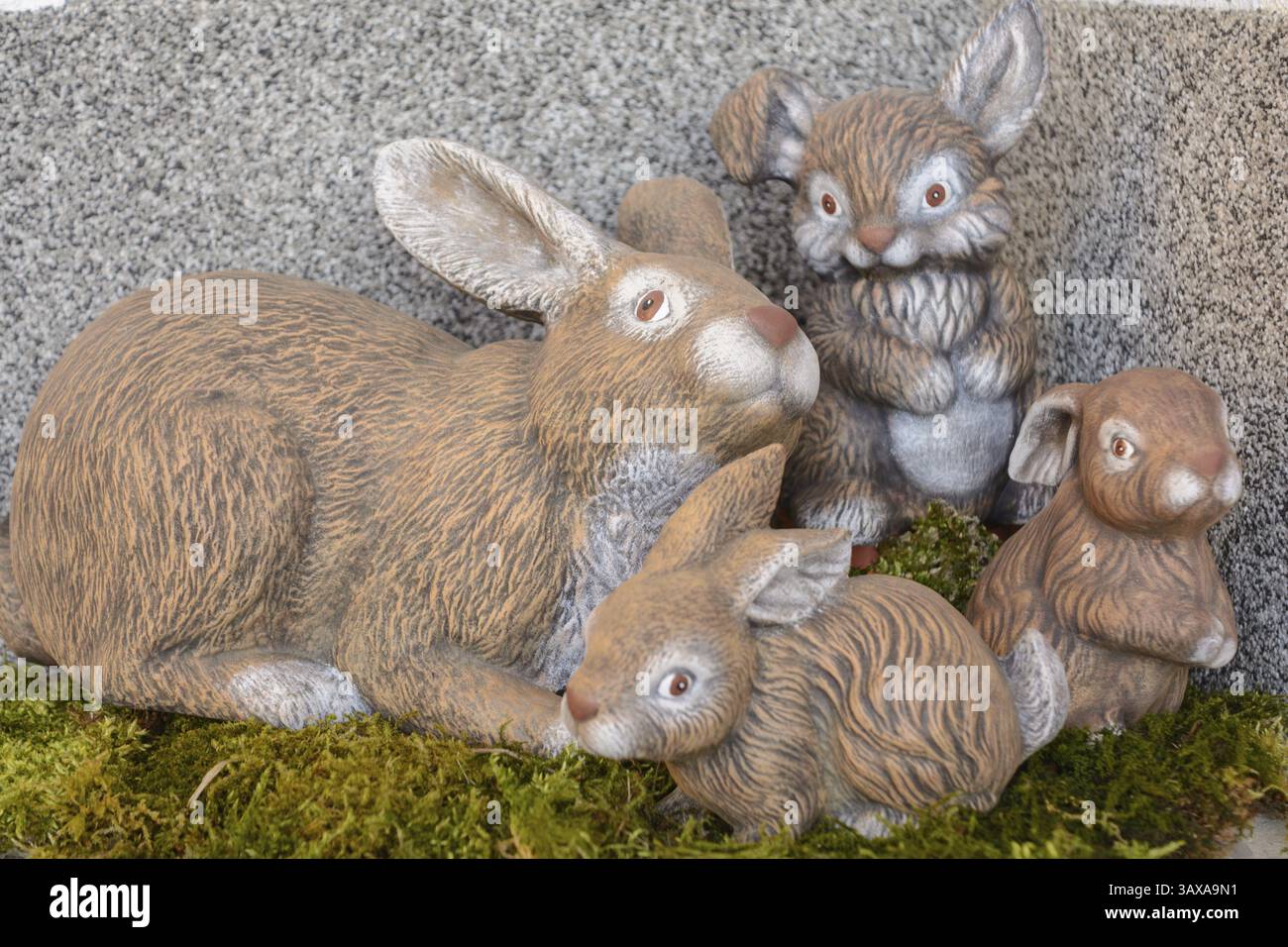 Graziose statuette decorative in ceramica di coniglio pasquale sul muschio Foto Stock