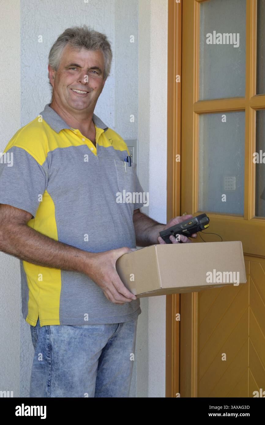 Il corriere consegna il pacco alla casa Foto Stock