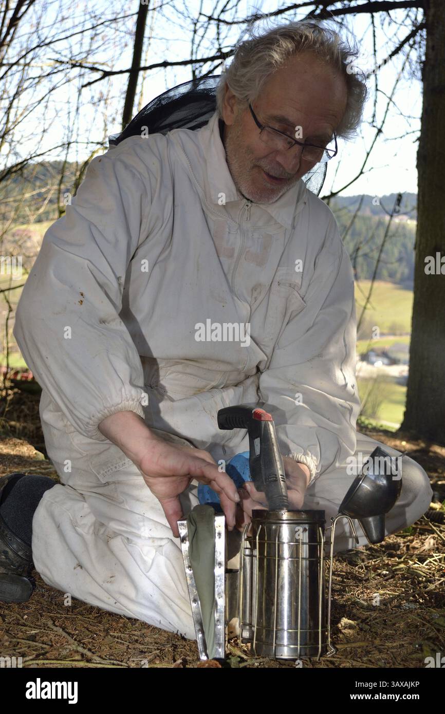 L'apicoltore prepara il fumatore per il suo lavoro Foto Stock