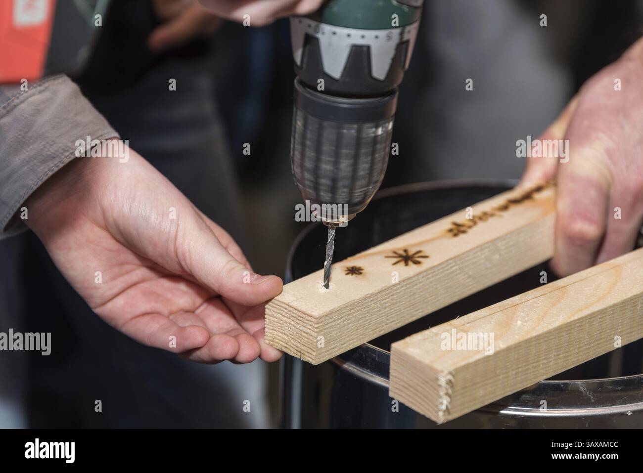Carpenter esegue un foro con un trapano a batteria - primo piano Foto Stock