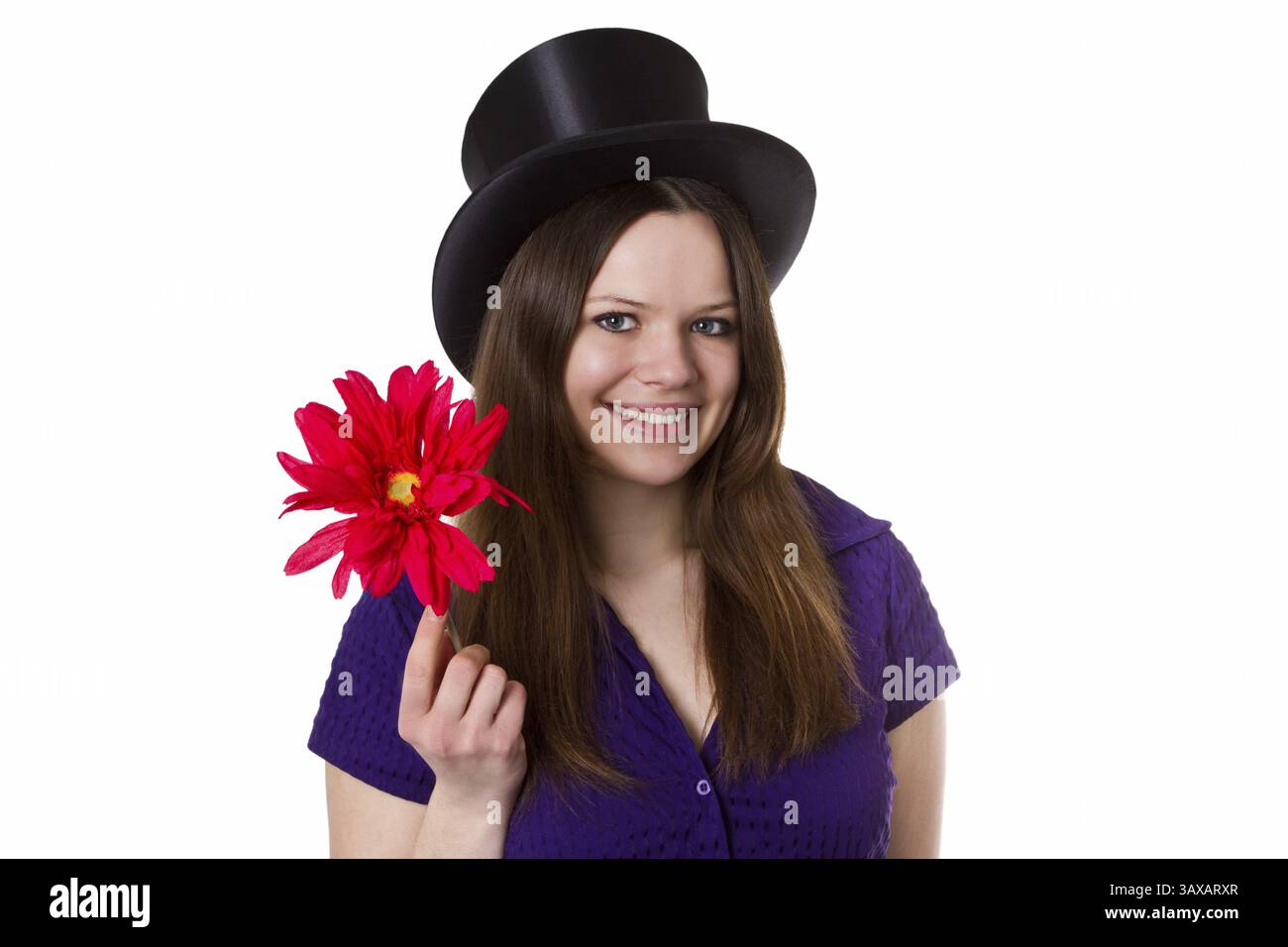 Giovane donna con cappello stovepipe che regge un fiore rosso - isolata giovane donna con cappello stovepipe che tiene un fiore rosso - isolata Foto Stock