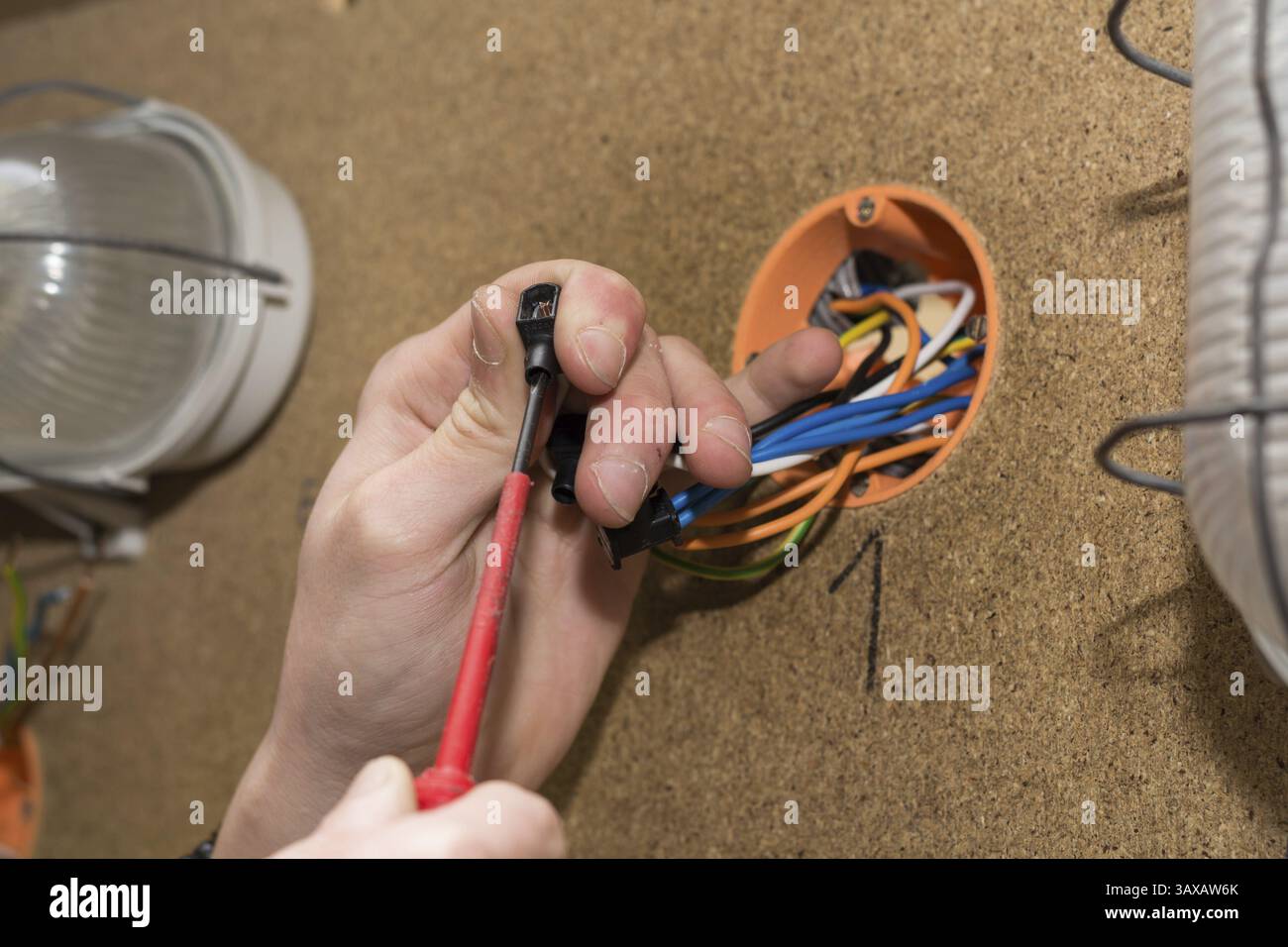 L'elettricista fissa i fili al terminale - impianti elettrici Foto Stock